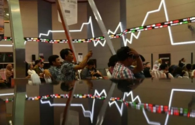 Ilustrasi - Sejumlah pengunjung duduk berlatar belakang pergerakan Indeks Harga Saham Gabungan di Bursa Efek Indonesia, Jakarta.